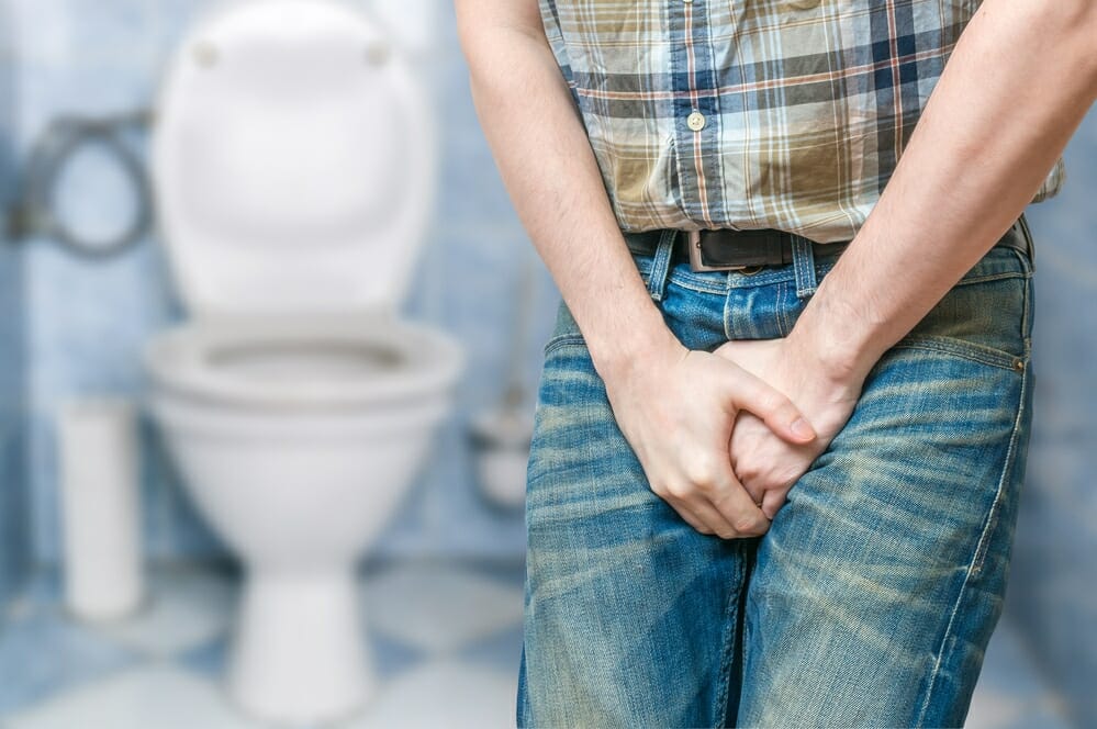mężczyzna mający problem z prostatą trzyma się za krocze